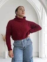 Sweater de punto grueso color bordó, con cuello alto y mangas largas.