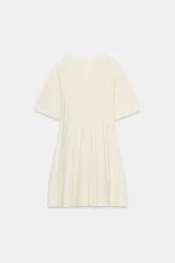 Vestido corto de punto rib color crema, con cuello redondo, manga corta abullonada y falda plisada.