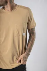 Remera de algodón color verde agua, con cuello redondo, mangas cortas y un bolsillo frontal en el pecho.