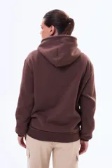 Buzo tipo canguro de felpa color marrón, con capucha ajustable mediante cordones y bolsillo frontal tipo canguro.