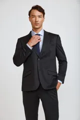 Ambo de corte slim compuesto por saco de dos botones y pantalón de vestir a juego, en color azul marino. El saco presenta solapas clásicas, bolsillos laterales con solapa y bolsillo en el pecho con pañuelo decorativo.