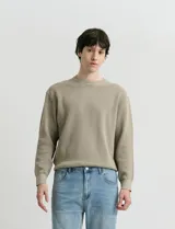 Sweater de punto con textura en color verde oscuro, de cuello redondo y manga larga.