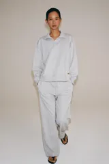 Pantalón ancho de felpa en color gris melange, con tiro medio y cintura elástica ajustable con cordón. Cuenta con bolsillos laterales ocultos en costura y diseño de pernera ancha.