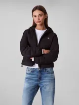 Campera puffer ligera Calvin Klein color negro, con diseño acolchado, capucha integrada, cierre frontal con cremallera y logo distintivo de la marca en el pecho.