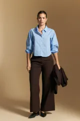 Pantalón de vestir negro de corte ancho y tiro alto, con silueta fluida y diseño minimalista.