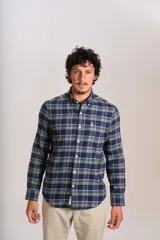 Camisa de manga larga confeccionada en tejido de franela con estampado de cuadros en tonos azul marino y verde. Presenta cuello abotonado, cierre frontal con botones y un bolsillo en el pecho con el logo bordado de la marca.