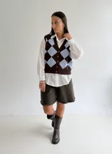 Chaleco tejido de punto con diseño de rombos en tonos marrón y beige, con escote en V y cierre frontal de botones.