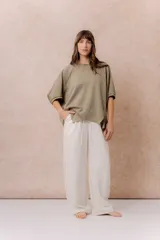 Pantalón de pierna recta color blanco off-white, de calce amplio y fluido. Posee cintura elastizada con cordón regulable y bolsillos laterales funcionales.