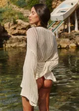 Sweater tejido color crudo, de manga larga y escote redondo. Tejido calado con caída relajada.