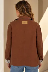 Campera marrón de lino con diseño bicolor, con una franja central gris claro que incluye botones de nácar. Cuenta con cuello alto, mangas largas con puños grises, bolsillos frontales aplicados y silueta amplia.