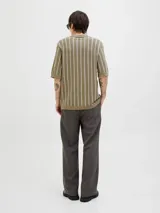 Polo de punto con fit relajado y diseño estructurado. Tejido estilo urbano con cuello tipo camisa, cierre con botones y mangas cortas.