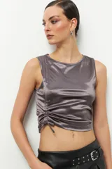 Top sin mangas de satén color gris topo, con cuello redondo y cordones laterales para fruncir.