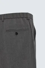 Pantalón de vestir regular fit color negro, confeccionado en tejido con mezcla de lana y elasticidad. Cuenta con cintura elástica, bolsillos frontales, bolsillos traseros de vivo con botón, y cierre frontal con cremallera y botón.