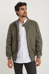 Campera estilo bomber color verde militar, con cierre metálico, dos bolsillos externos con cierre y un bolsillo interno.