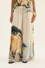 Pantalón palazzo de seda color crema con estampado de paisaje.