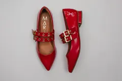 Chatitas rojas de charol con punta fina y dos tiras sobre el empeine con ojales metálicos y hebillas doradas.