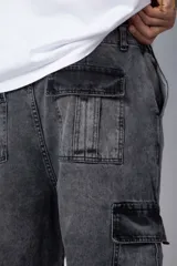 Pantalón jean cargo de corte oversize y tiro medio, con bolsillos laterales tipo cargo y costuras reforzadas en las rodillas.