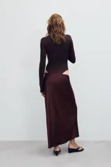 Falda midi de tiro alto y cintura elástica, confeccionada en tejido satinado de color negro.