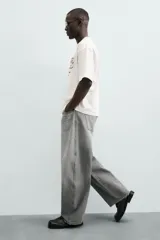 Jeans de hombre, corte balloon fit, tiro medio, confeccionados en denim rígido de algodón. Presentan un efecto lavado con un marcado degradado vertical, cinco bolsillos y cierre frontal con cremallera y botón.