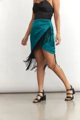 Minifalda cruzada color turquesa de seda con flecos negros en el borde.