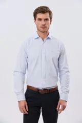 Camisa de vestir de manga larga con diseño de rayas finas celestes y blancas, cuello clásico y cierre frontal con botones. Incluye pequeño logo bordado en el pecho.