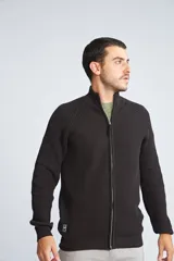 Campera tejida de algodón con cierre frontal completo, cuello alto y mangas largas con puños acanalados. Presenta un diseño de punto acanalado vertical y un pequeño logo bordado en el ruedo.
