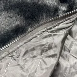 Campera de textura afelpada en color negro, con cuello alto y cierre frontal. Presenta letras bordadas en color blanco en la espalda y en las mangas. Cuenta con ajuste en la cintura y un corte regular.