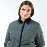 Chaqueta corta con estampado floral en tonos rosa y celeste sobre fondo negro. Tiene cuello mao y cierre frontal con botones a presión.