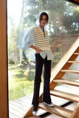 Jean negro de tiro alto, corte acampanado (flare) y costura central marcada en el frente de ambas piernas.