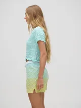 Short de punto tejido con patrón de rombos en tonos degradados de celeste y amarillo. Presenta una pretina elástica y un calce suelto.