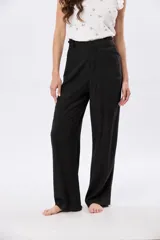 Pantalón de lino y viscosa color negro, de tiro alto con media cintura elastizada, pierna amplia y detalle trenzado lateral.