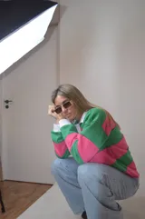 Sweater a rayas horizontales rosas y verdes, con cuello polo blanco y puños blancos.