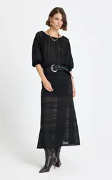 Pollera midi de punto color negro, con diseño calado y franjas horizontales de diferentes texturas. Presenta un corte entallado que se ensancha ligeramente hacia el ruedo.