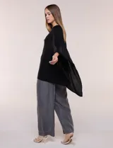 Poncho de calce holgado color marrón, confeccionado en tejido fino de punto suave, con cuello redondo y diseño de caídas laterales amplias de ruedo asimétrico.