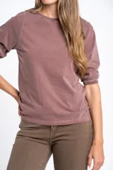 Remera de algodón color blanco roto, con escote redondo y mangas globo de tres cuartos con elástico en el puño.