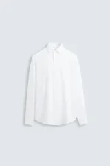 Camisa de corte slim fit con textura, cuello italiano y manga larga con puños abotonados. Presenta cierre frontal con botones.