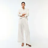 Pantalón palazzo de lino mezclado, color blanco con diseño de rayas verticales finas en color negro, de corte ancho y tiro alto con cintura elástica.