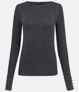 Suéter de punto color rosado, con cuello barco, mangas largas y puños con botones decorativos. El dobladillo también es acanalado.