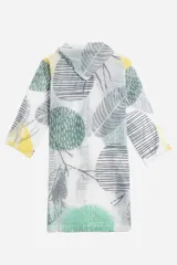 Piloto impermeable de corte recto y largo midi, con capucha ajustable mediante cordones. Presenta un diseño estampado con motivos botánicos en tonos verdes y amarillos sobre una base translúcida. Cuenta con cierre frontal mediante botones a presión y mangas largas.