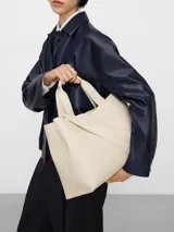 Bolso shopper horizontal de poliuretano color beige, con dos compartimentos, cierre magnético, bolsillo interior con cierre, asa de mano y asa larga regulable y extraíble. Incluye logo grabado en el frente.