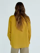 Camisa celeste de mangas 3/4 con volados en el frente y cuello en V.