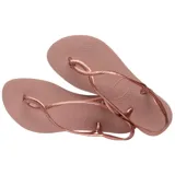 Ojotas Havaianas modelo Luna, color rosado metalizado, con tiras finas que se cruzan y forman un lazo en el empeine, y tiras traseras ajustables.
