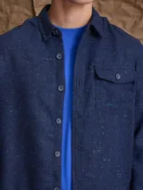 Overshirt de textura tipo tweed en color marrón, con cuello clásico, cierre frontal de botones y bolsillo en el pecho.