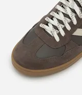 Championes de estilo deportivo tipo chutera, confeccionados en poliuretano con recortes en contraste. Presentan punta redondeada, cordones bicolores y suela plana color caramelo.