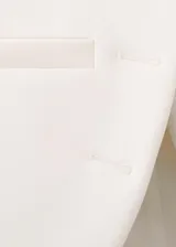 Chaqueta de diseño recto color blanco, con cuello mao, manga larga con puños abotonados, cierre frontal de botones y bolsillos de ribete delanteros.