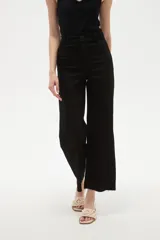 Pantalon tipo jean de corte flare y tiro alto, color verde oscuro, con cierre frontal y bolsillos.