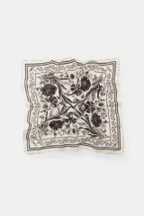 Pañuelo bandana de algodón blanco con estampado floral en tonos marrones y negros, con bordes decorados con abalorios a contraste.