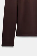 Camiseta de manga larga y cuello redondo, con corte ajustado al cuerpo.