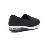 Zapato casual tipo slip-on de lycra color negro, con suela de plataforma blanca y cámara de aire en el talón. Presenta un aplique circular metálico con logo en el empeine.