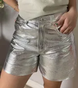 Short de cuero plateado con acabado metalizado y efecto arrugado, corte estilo jean de tiro medio y largo por encima de la rodilla.